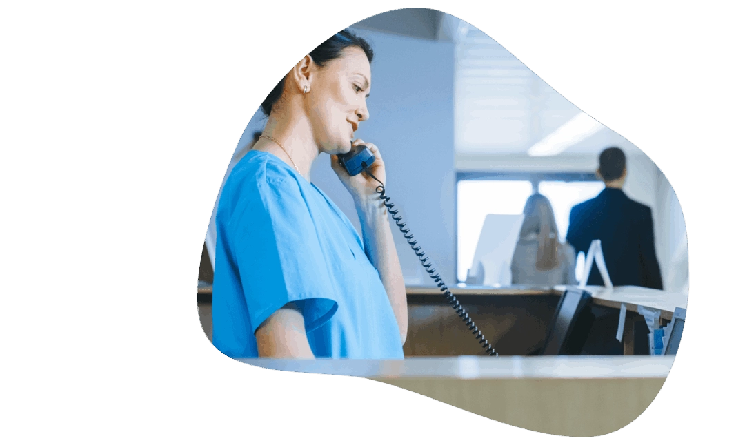 Woman using business phone service in hospital front desk